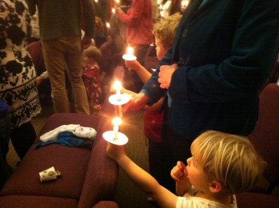 Zion, Grandma, and Harvey holding candles in church