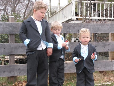 three boys in new Easter suits, posing by the fence