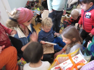 lots of kids crowding round as Lijah opens a present