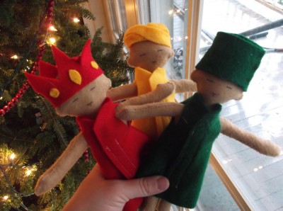 the three felt kings held in front of the Christmas tree