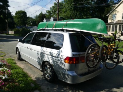 our van ready to go with canoe on top and bikes on back