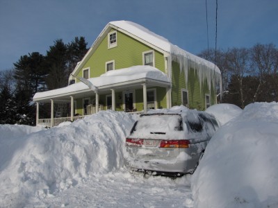 our house with lots of snow in front of it and lots of icicles on the eves