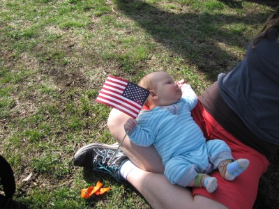 Elijah lying in Leah's lap holding an American flag