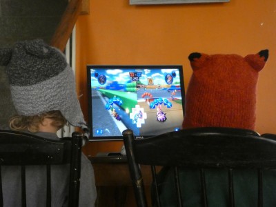Zion and Elijah in animal winter hats playing MarioKart