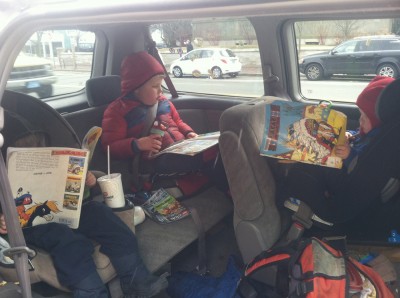 three boys reading three comic books in three car seats