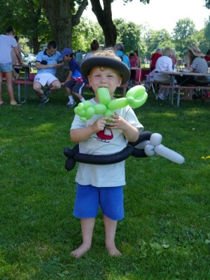 Lijah with a balloon hat, sword-belt, and pet