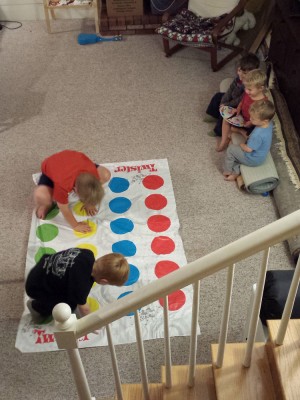 Harvey and Nathan playing Twister, the other kids manning the spinner
