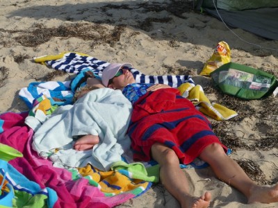 Mama and Lijah napping on the beach in a nest of towels
