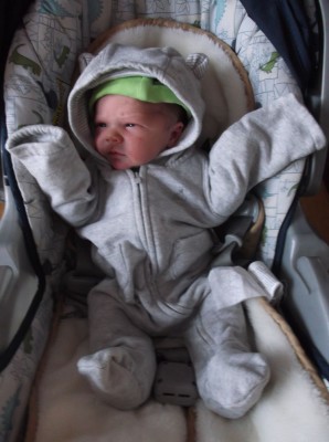 Elijah in the carseat wearing a hooded oversuit