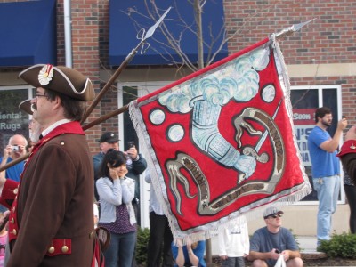 A Bedford minuteman carrying the town flag in the parade