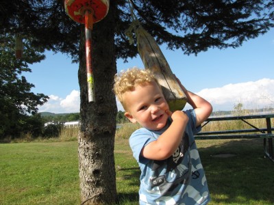 Lijah tugging on lobster bouys hanging from a tree