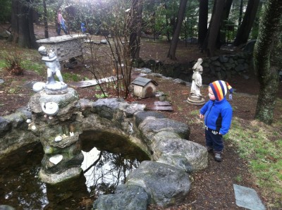 Lijah looking at a fountain in the scraggely monastary garden