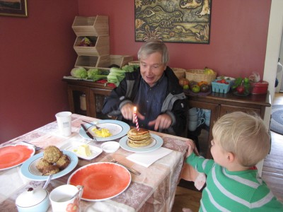 Grandpa and a stack of pancakes with a candle stuck in them