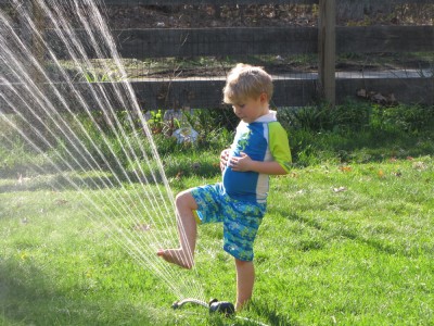 Zion playing in the sprinkler