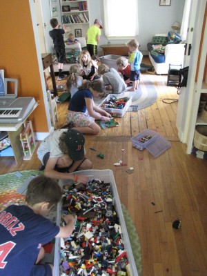 kids building with lots of legos on the living room and playroom floor