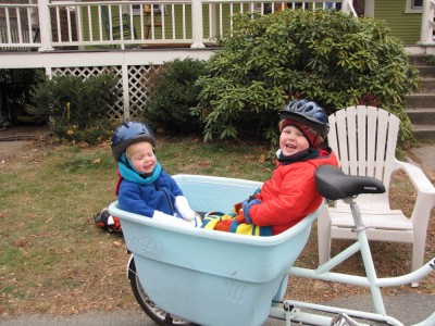 Harvey and Zion in the back of the big bike, well bundled up, outside our house