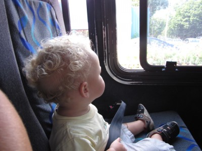 Lijah sitting in his own seat on the bus, looking out the window