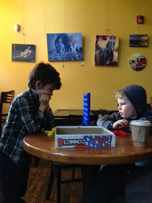 Hendrick and Harvey playing Connect-4 in a hip cafe