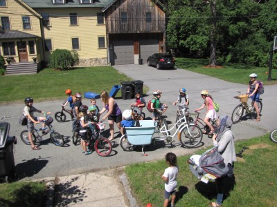 a crowd of kids stradling bicycles ready to ride