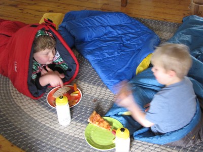 Harvey and Zion in their sleeping bags in the living room eating lunch