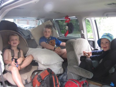 the boys in their car seats amidst the camping gear