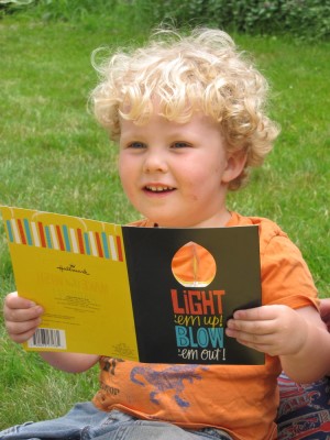 Harvey holding a musical birthday card with a spinning candle flame