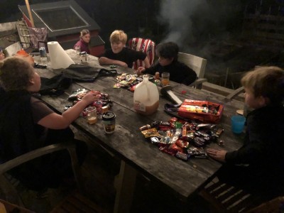 the boys and friends sorting their candy at the picnic table