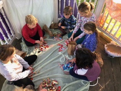 kids sitting in a gazebo with piles of candy