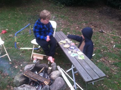 Harvey and Zion looking at Pokemon cards by the fire