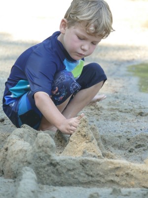 Elijah concentrating on building a sandcastle