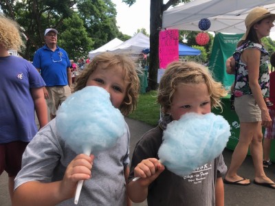 Zion and Elijah eating blue cotton candy amidst the crowd