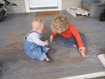 Zion and Harvey drawing with chalk on the porch