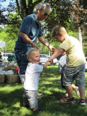 three boys playing ring-around-the-rosie with Grandpa at the farmers market