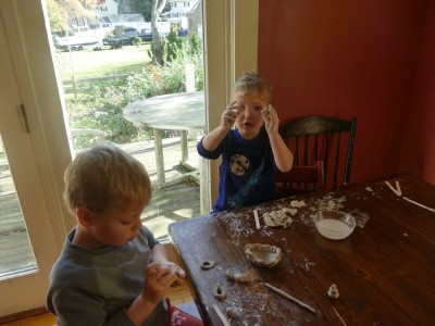 Lijah and Zion working with clay at the kitchen table