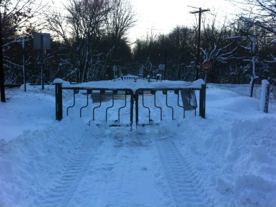 a closed gate blocking the plowed portion of the bike path