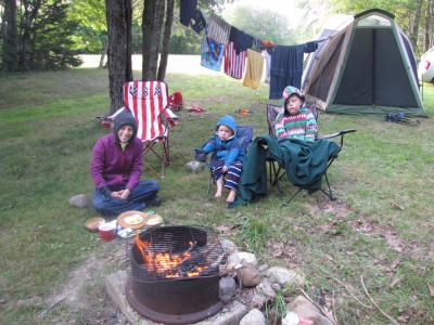 Mama, Harvey, and Lijah in warm pjs and sweatshirts in front of the tent