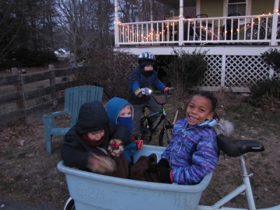 Nisia, Zion, and Lijah bundled up in the blue bike; Harvey on his bike with light