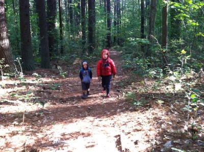 Zion and Harvey walking in the woods; Harvey with winter jacket