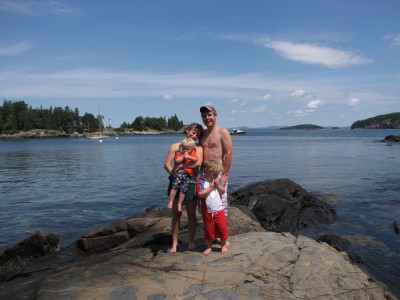 the Archibalds posing on a rock in the waters of Compass Harbor