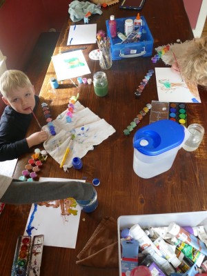 colorful paints on the kitchen table as the boys work