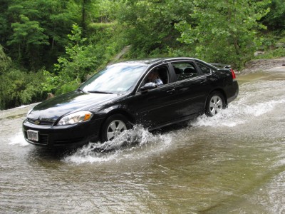 a car driving through the creek at the ford