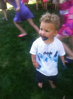 Lijah in the midst of a birthday party covered with blue frosting