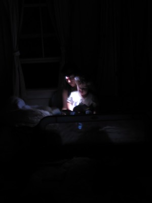 Mama and Harvey reading by the light of the headlamp