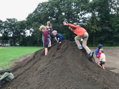 kids playing on a big dirt pile