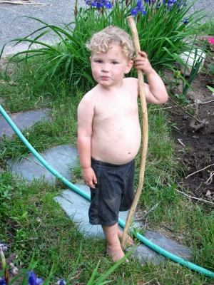shirtless and dirty Lijah posing holding his staff