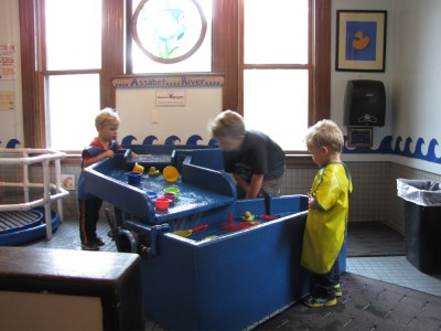 the boys playing in the water table at the childrens museum