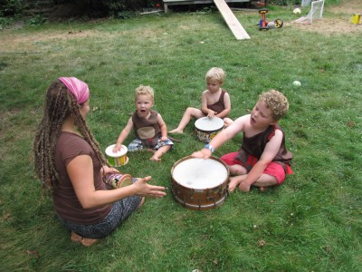 Mama leading the boys in a drum circle on the lawn