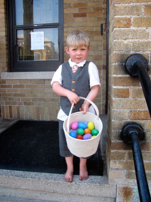 suited and barefoot Zion on the steps with a basket full of eggs