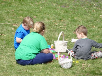 the boys sitting on the lawn opening their easter eggs