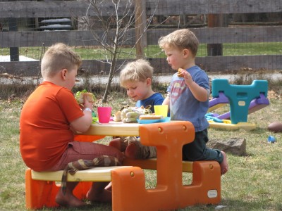 the boys sharing a picnic at the plastic table